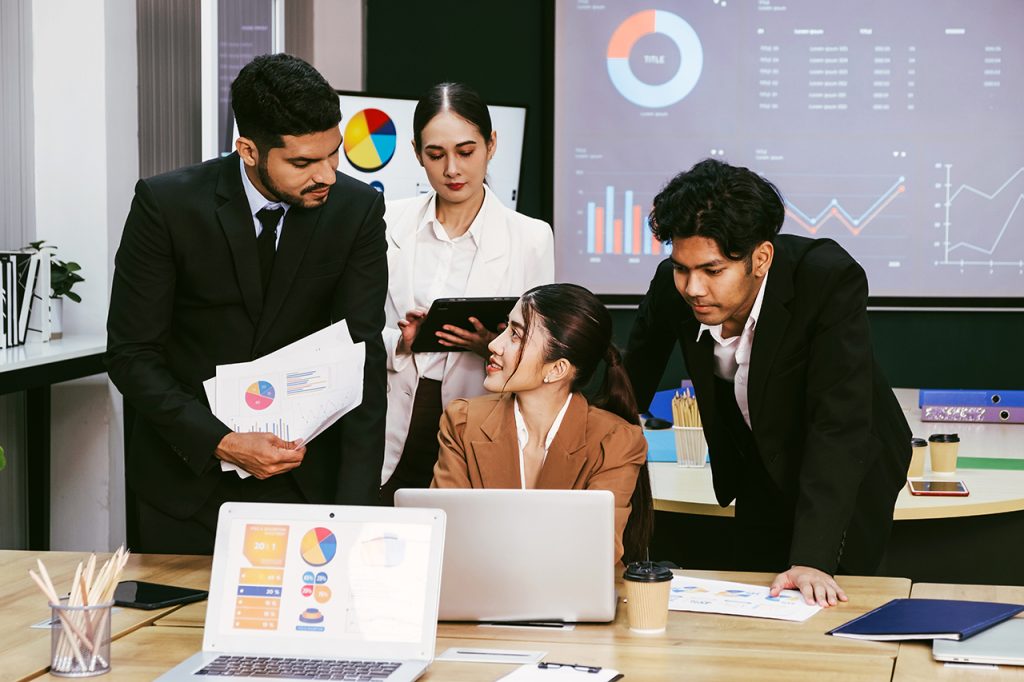 cheerful-confident-asian-businesswoman-stands-back-her-office-colleagues