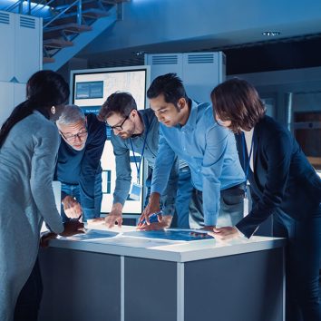 engineers-meeting-technology-research-laboratory-engineers-scientists-developers-gathered-around-illuminated-conference-table-talking-finding-solution-inspecting-industr